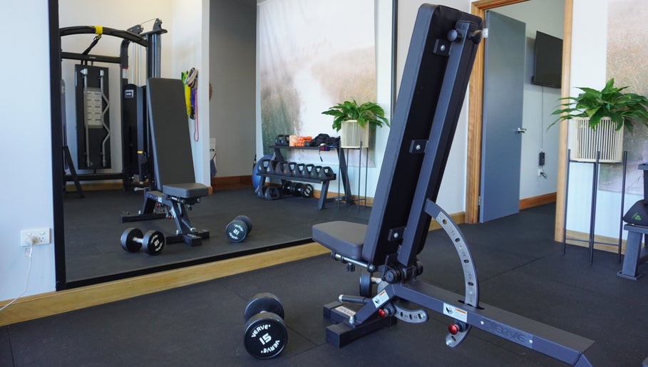 Modern fitness area at Studio You, Burnt Pine, NF with weights and equipment.