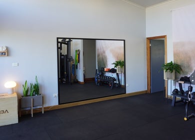 Spacious fitness area at Studio You in Burnt Pine, NF, featuring equipment and modern decor.