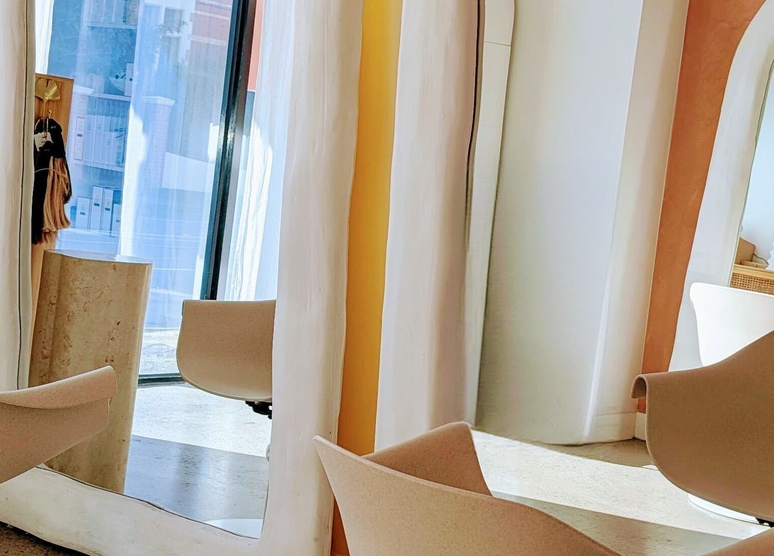 Modern salon interior at Lia Hanson Hair, Melbourne, Victoria, AU, featuring elegant mirrors and stylish chairs.