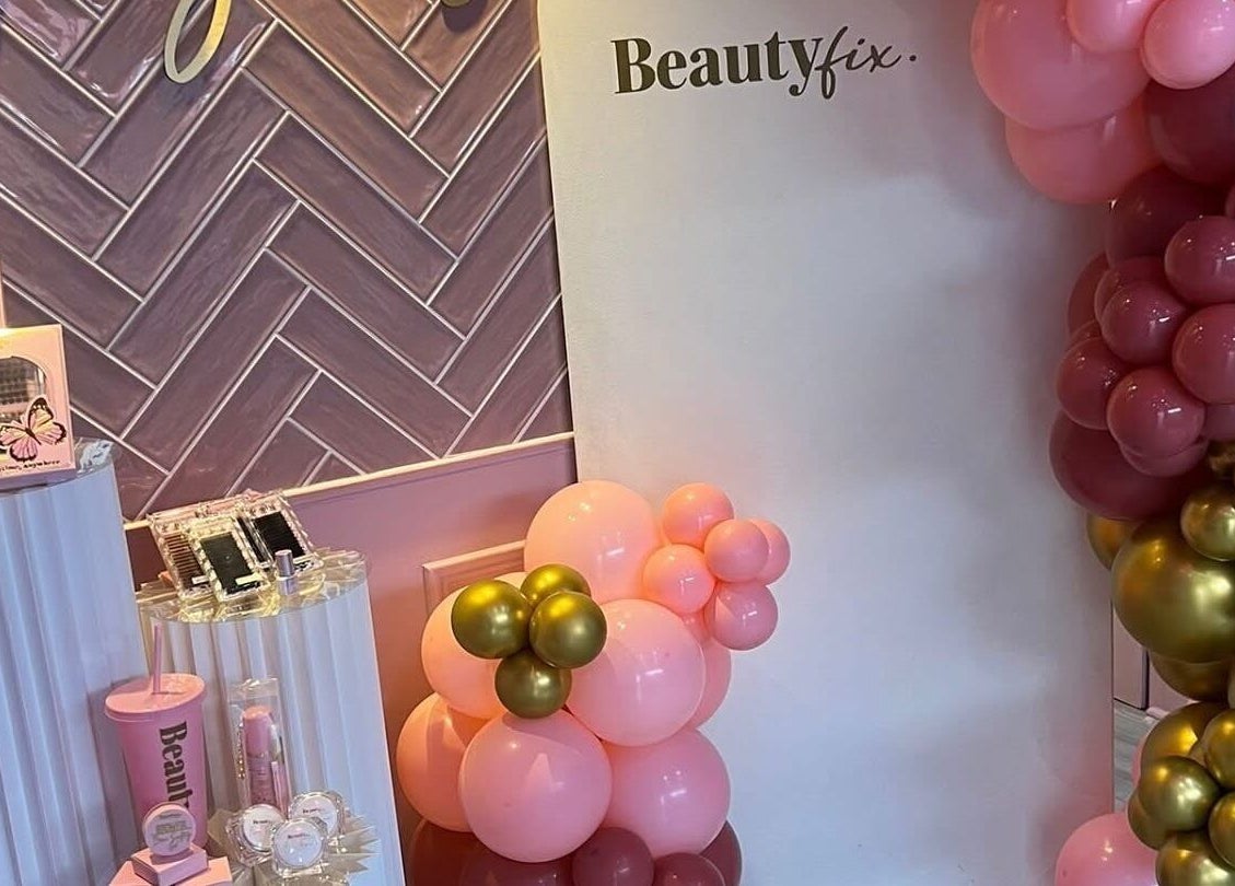 Jess @ Beautyfix in Sheffield, England, GB showcases a chic display with pink and gold balloons and beauty products.