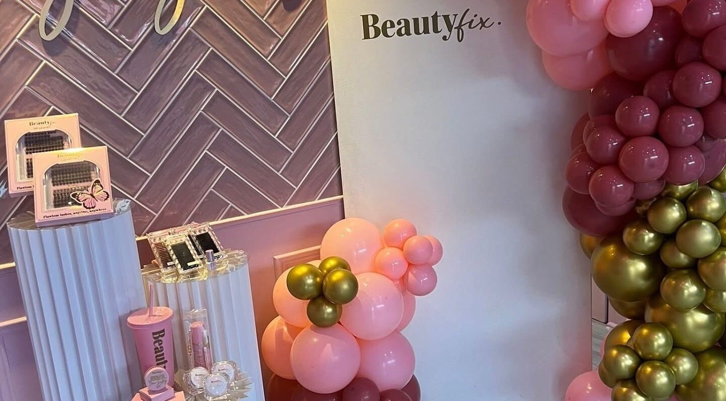 Jess @ Beautyfix in Sheffield, England, GB showcases a chic display with pink and gold balloons and beauty products.