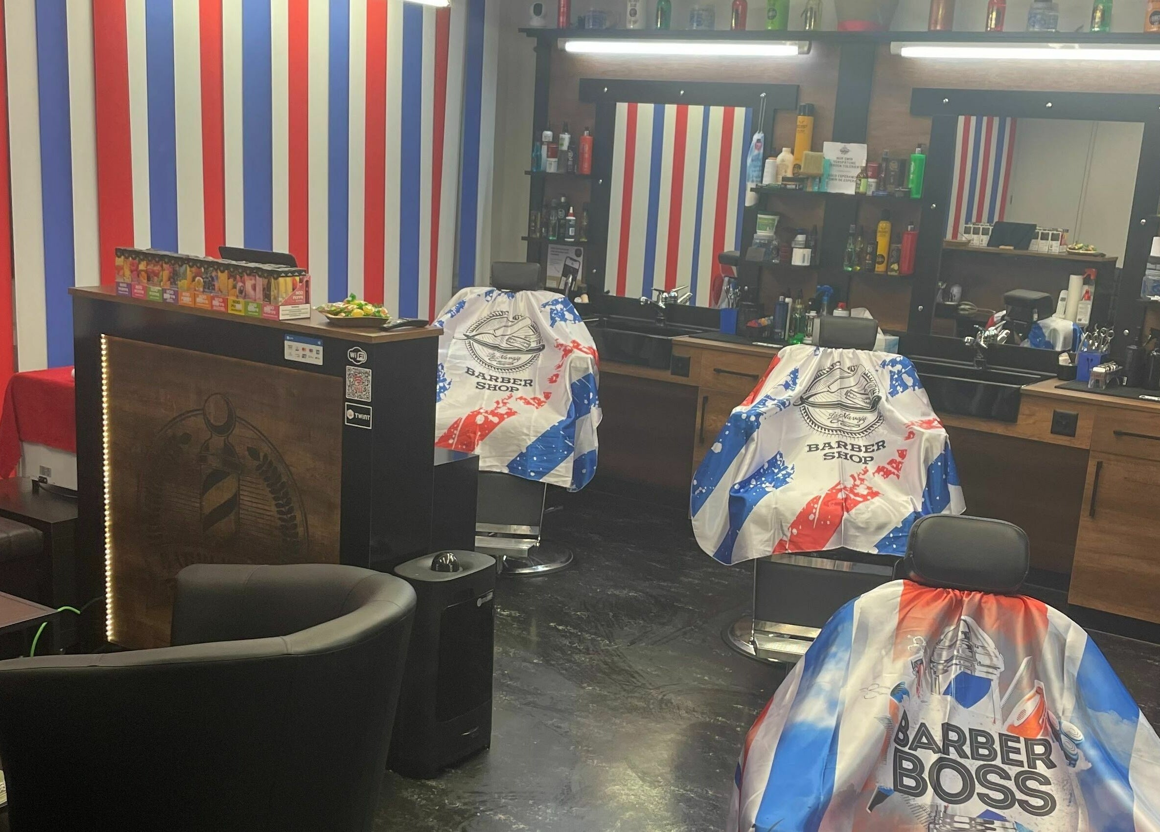 Modernes Innendesign bei The Latins Barbershop in Bern, Bern, CH mit bunten Streifen und gemütlichen Stühlen.