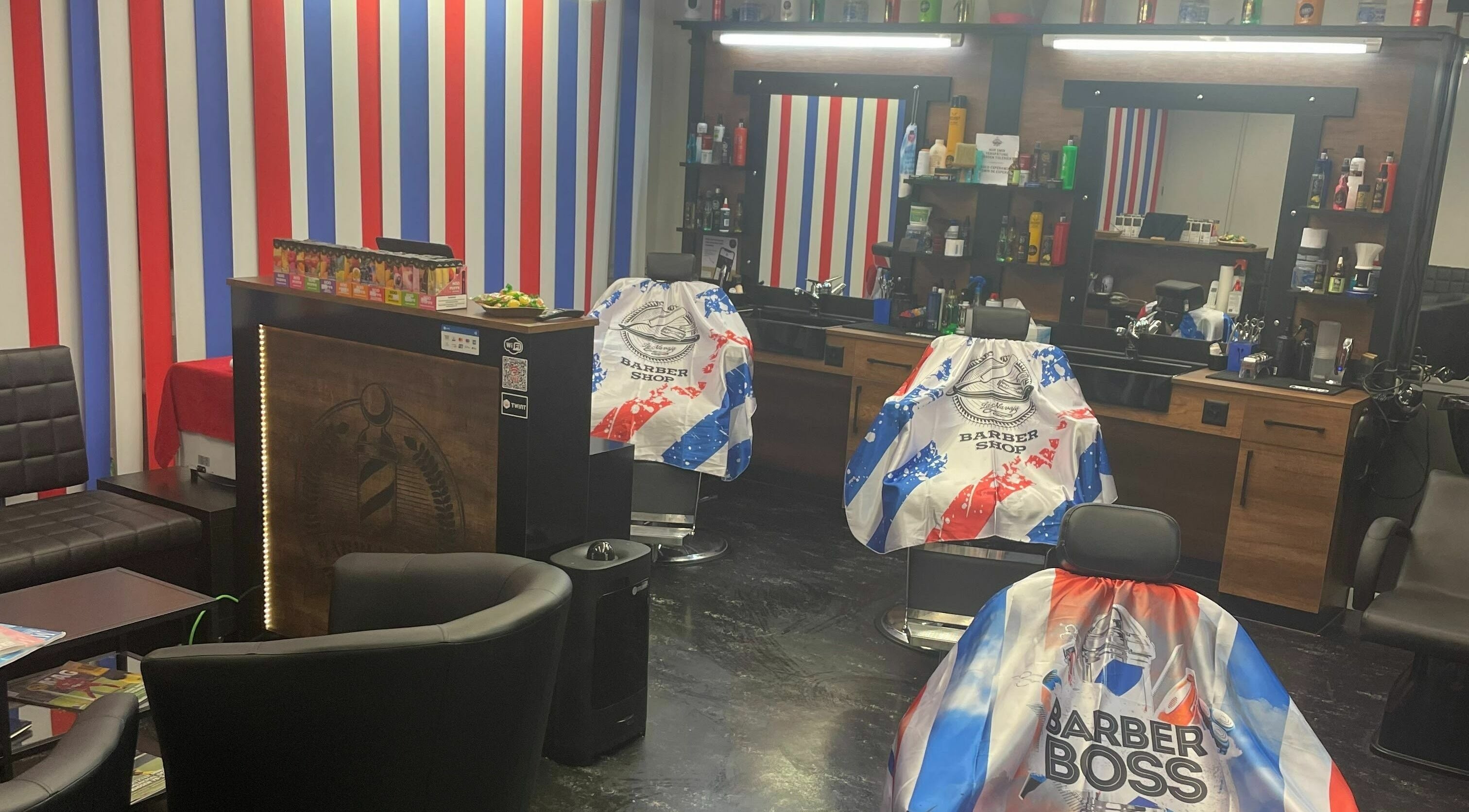 Modernes Innendesign bei The Latins Barbershop in Bern, Bern, CH mit bunten Streifen und gemütlichen Stühlen.