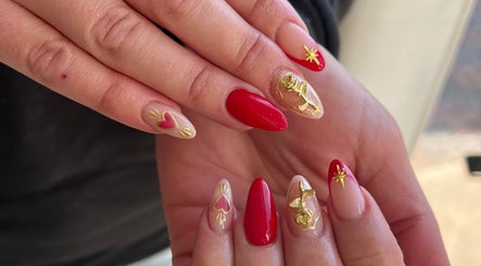 Vibrant red and gold nail art at Beauty by Design, Gqeberha, Eastern Cape, ZA, showcasing intricate designs.