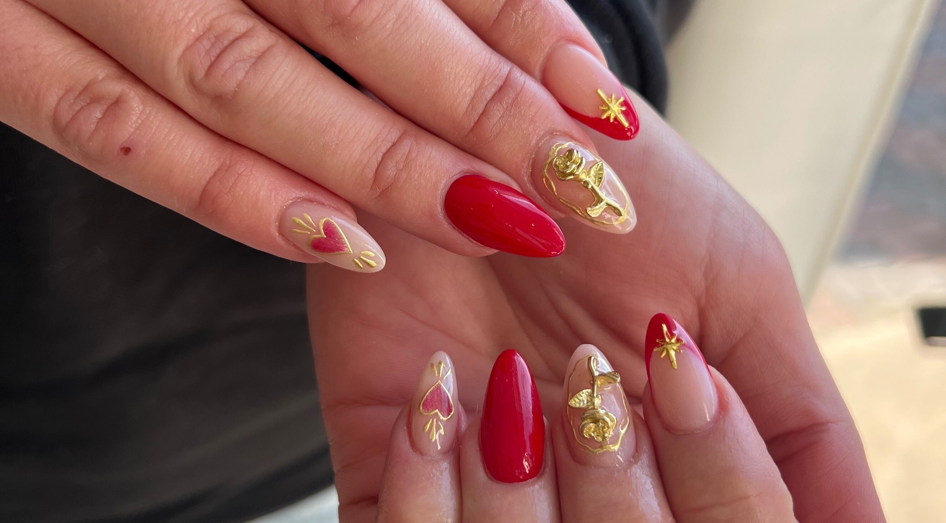 Vibrant red and gold nail art at Beauty by Design, Gqeberha, Eastern Cape, ZA, showcasing intricate designs.