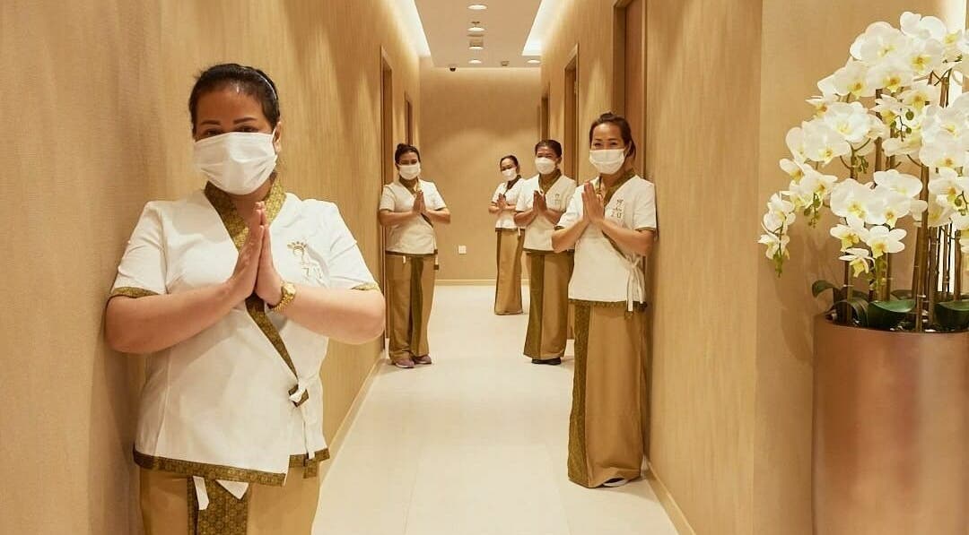 Welcoming staff at The ZUU Ladies Massage Spa Lounge | Home Service in Dubai, Dubai, AE hallway with orchids.