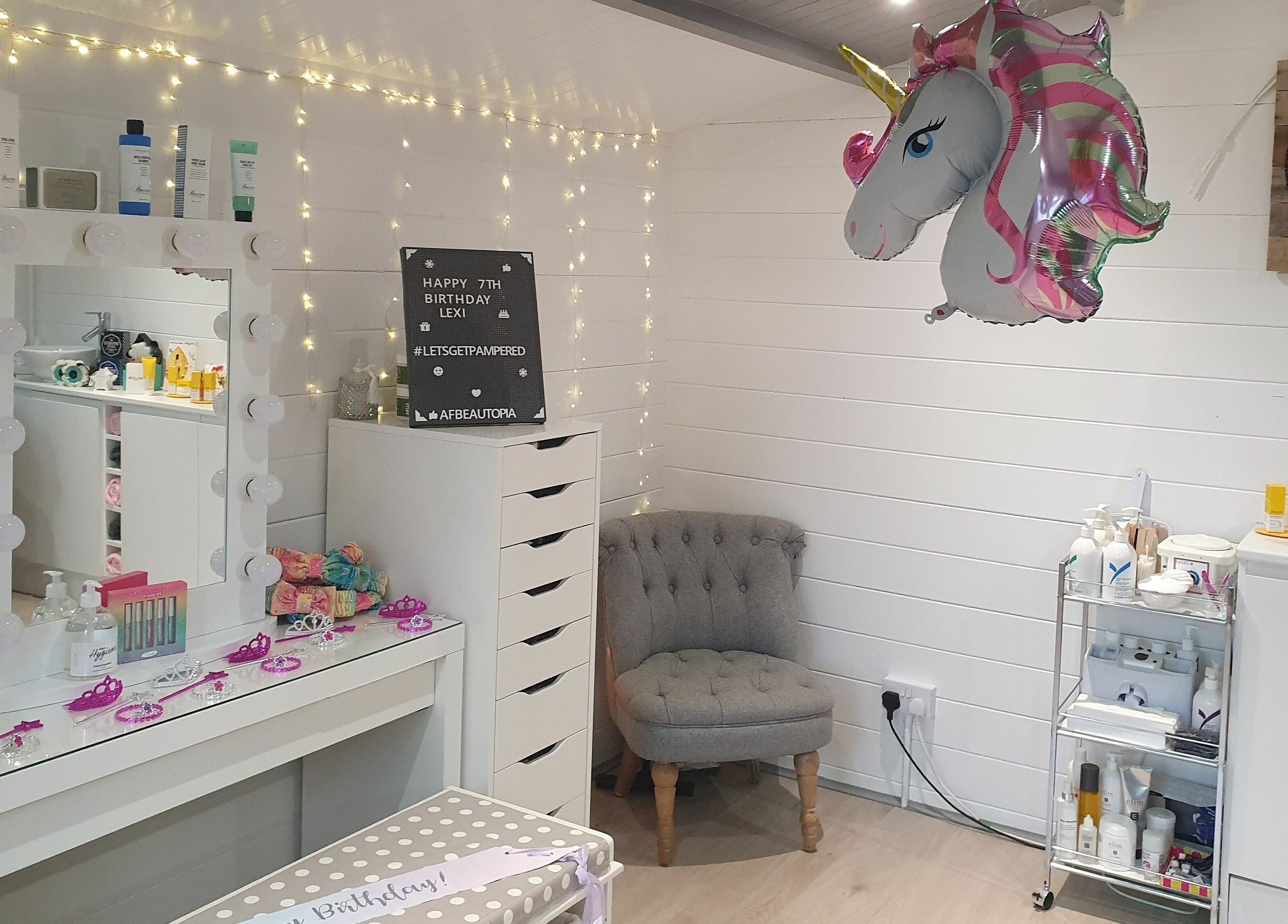 Chic beauty room at Beautopia, BANFF, GB with unicorn decor, vanity mirror, and cozy seating.
