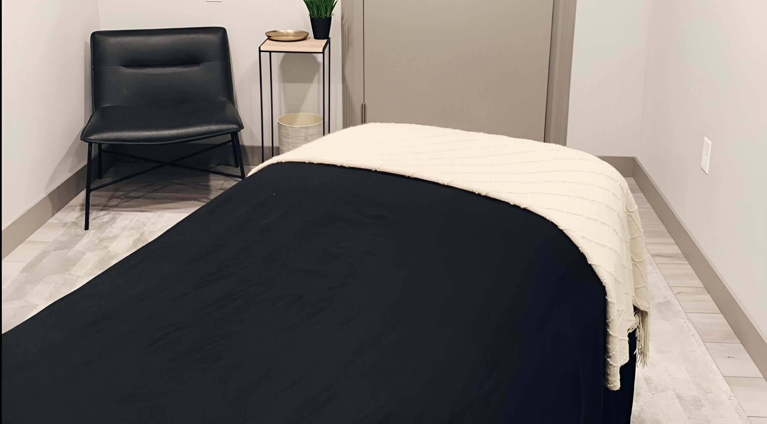 Cozy massage room at The Valley Day Spa and Salon in Pender, Nebraska, US, featuring a sleek black chair.