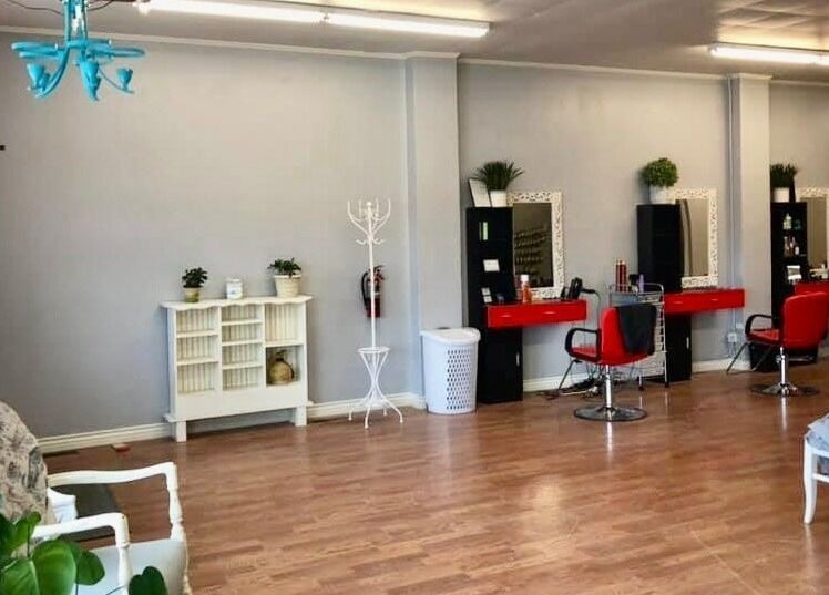 Elegant salon interior at Hip2BU, Kimberly, Idaho, US, featuring chic red chairs and tasteful decor.
