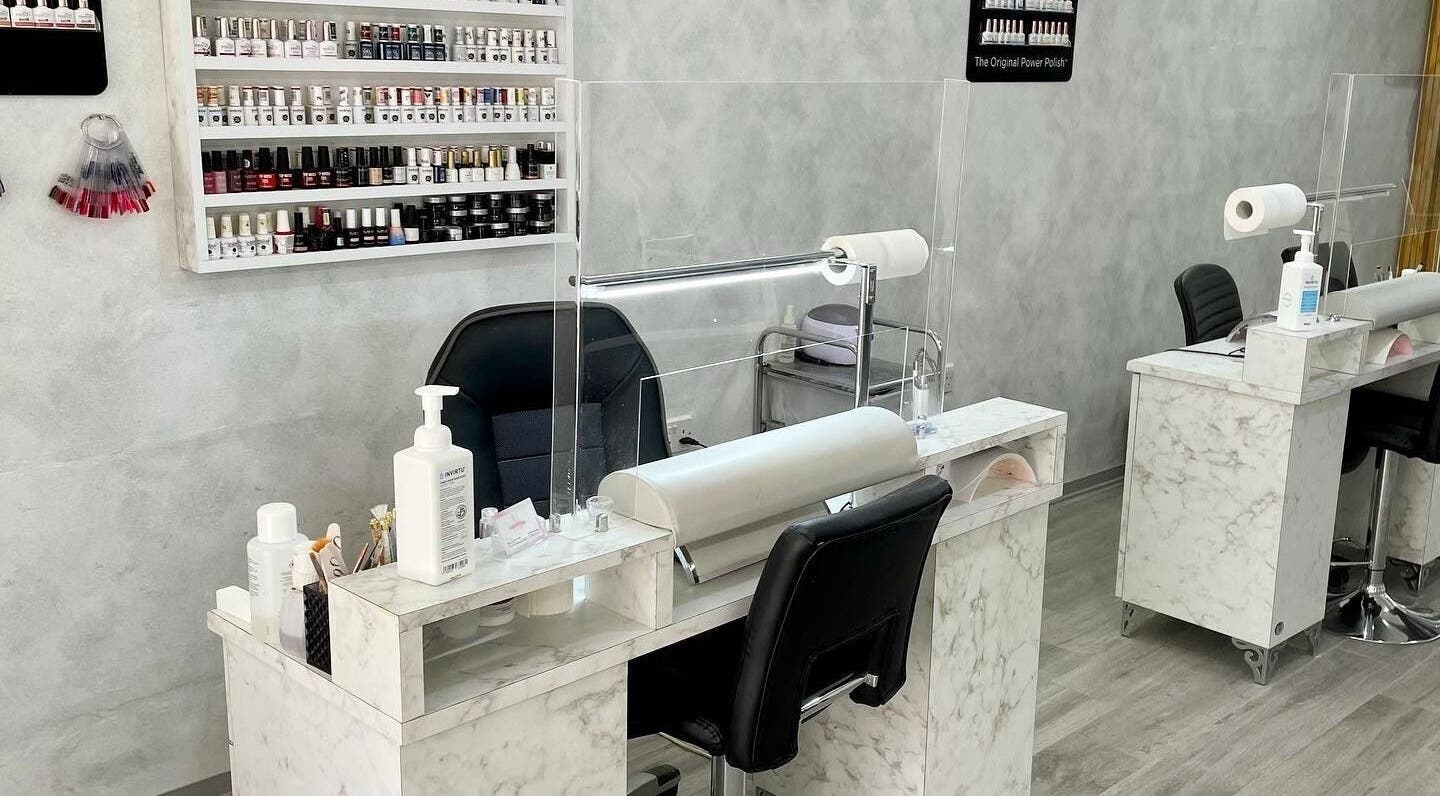 Elegant manicure station at RT Nail Studio, Ħ'Attard, MT, featuring marble countertops and chic black chairs.