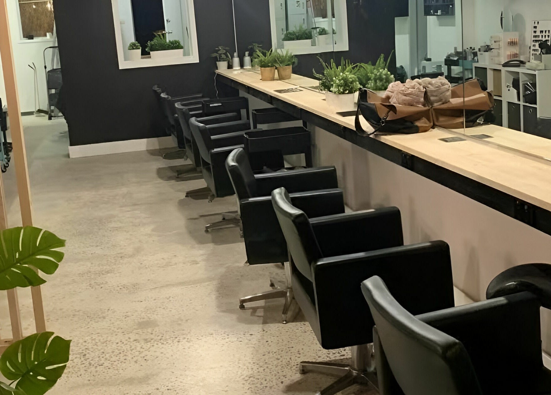 Modern salon interior at Salti Blonde and Co., Melbourne, Victoria, AU with stylish black chairs and plants.