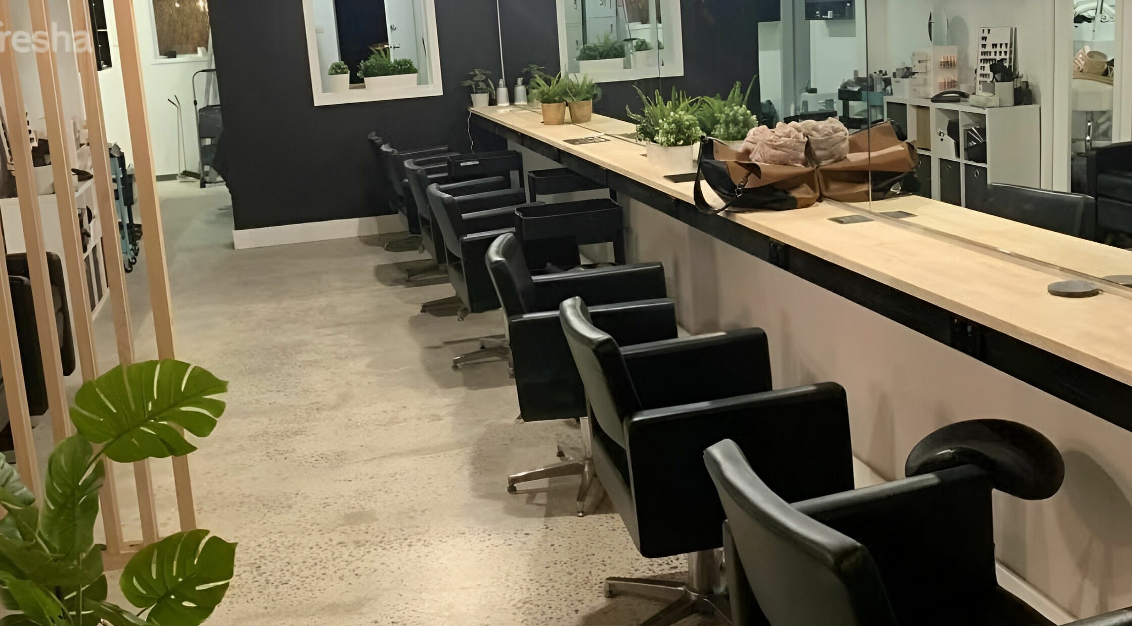 Modern salon interior at Salti Blonde and Co., Melbourne, Victoria, AU with stylish black chairs and plants.