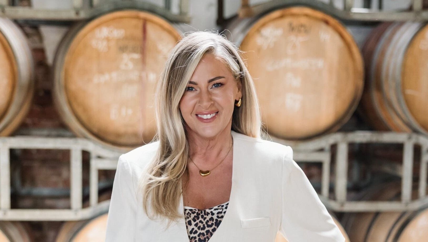 Woman smiling at Makeup by Tania Ferguson, Armstrong Creek, Victoria, AU with barrels in the background.