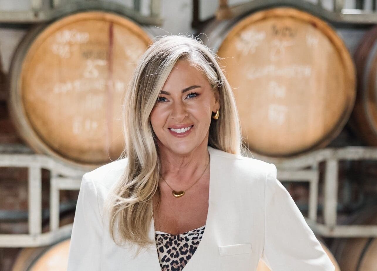 Woman smiling at Makeup by Tania Ferguson, Armstrong Creek, Victoria, AU with barrels in the background.
