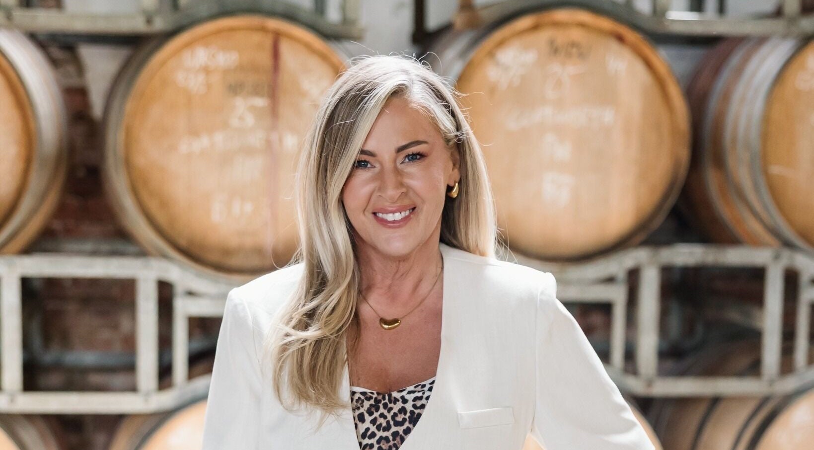 Woman smiling at Makeup by Tania Ferguson, Armstrong Creek, Victoria, AU with barrels in the background.