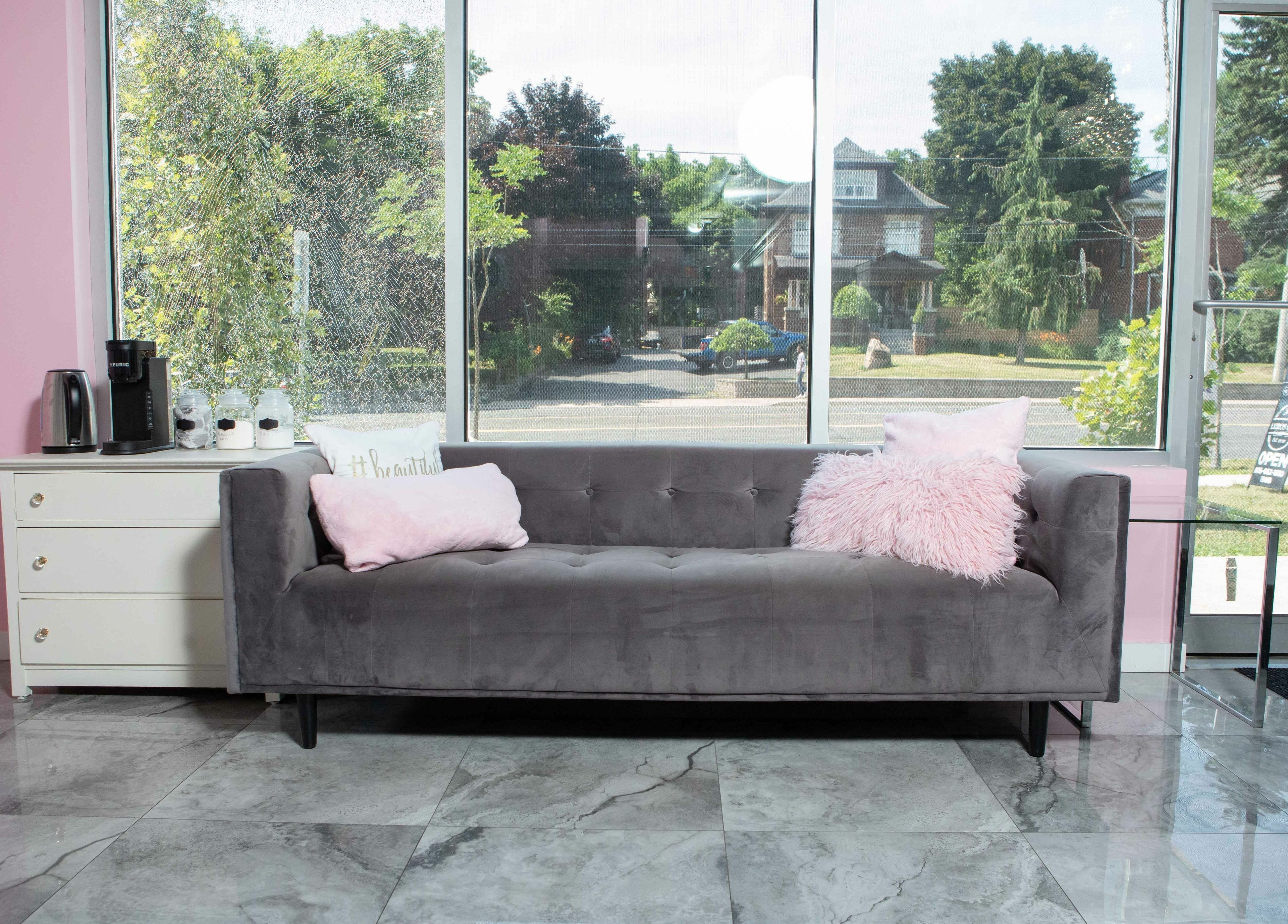 Inviting lounge with gray sofa at Elva Medical Aesthetics, Stoney Creek, Hamilton, Ontario, CA.