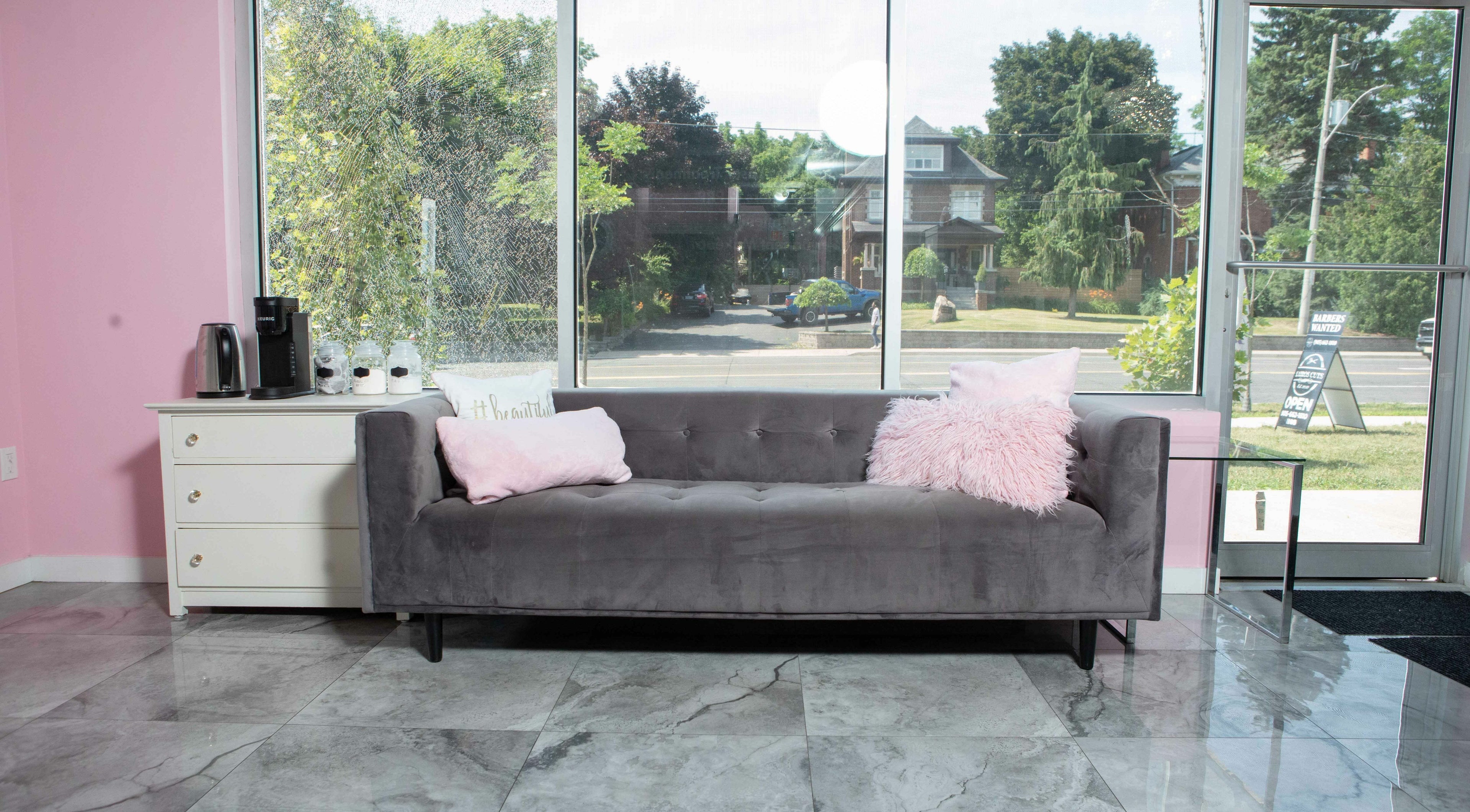 Inviting lounge with gray sofa at Elva Medical Aesthetics, Stoney Creek, Hamilton, Ontario, CA.