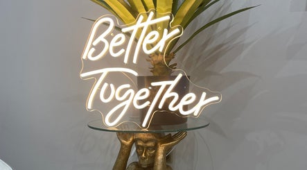 Illuminated 'Better Together' sign at 11:11 Studios, Leicester, England, GB, alongside green plant decor.