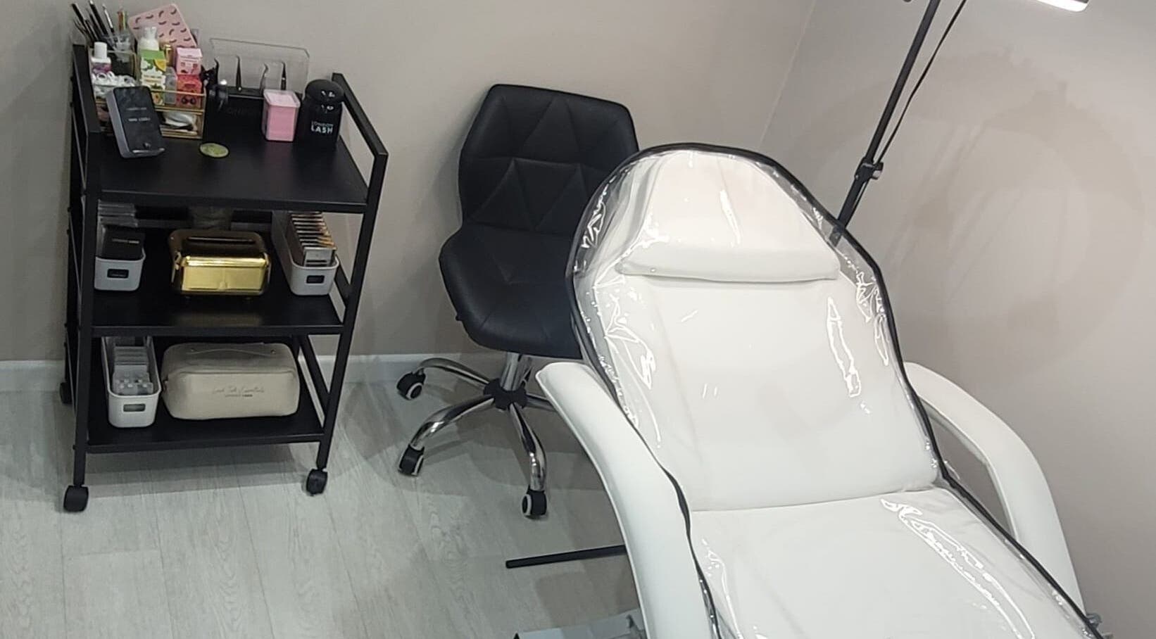 11:11 Studios in Leicester, England, GB features a modern treatment chair and organized beauty supplies.