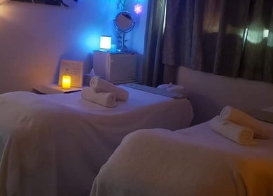 Relaxing spa room at Beauty Home Spa, Saskatoon, SK. Features candlelit ambiance and two massage tables for ladies.