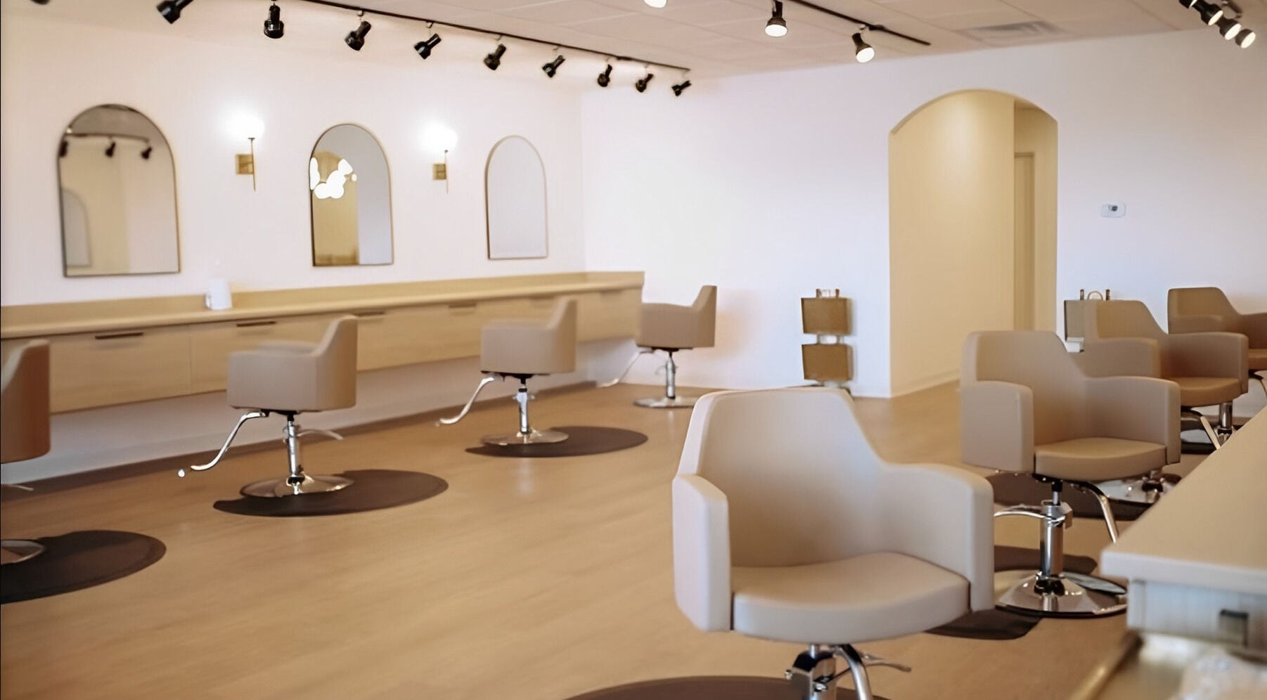 Modern salon interior at Marissa Beyer at Hey Honey Hair in Holland, Michigan, US featuring plush beige chairs.