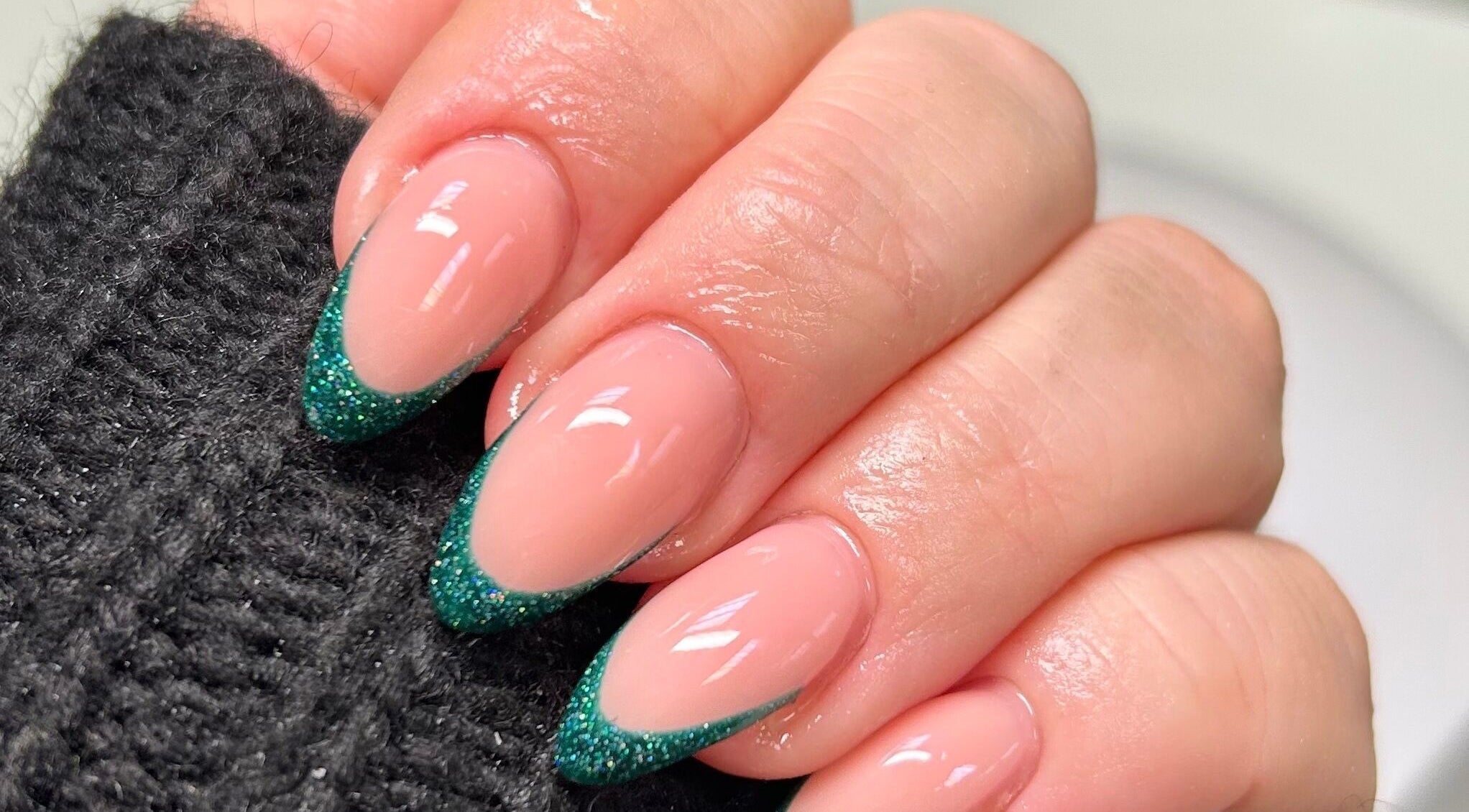 Elegant green glitter French nails at FNBC Salon, Leicester, England, GB. Perfect blend of style and sophistication.