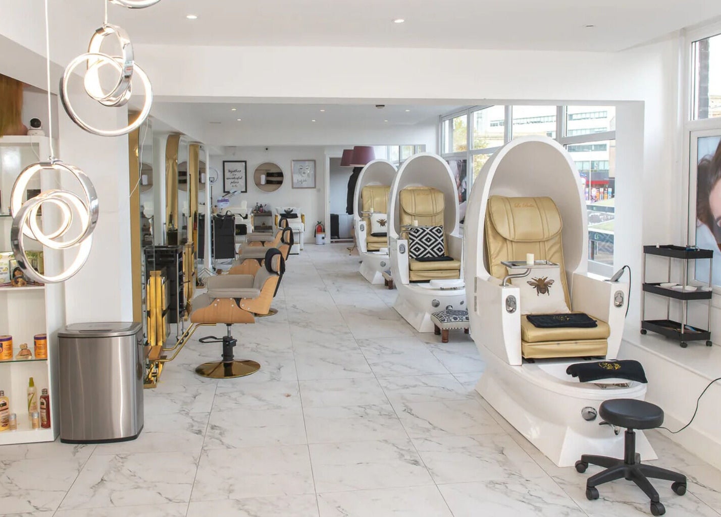 Interior view of La Bella Aesthetic Clinic, Salford, England showcasing sleek, white spa chairs and beauty product shelves.