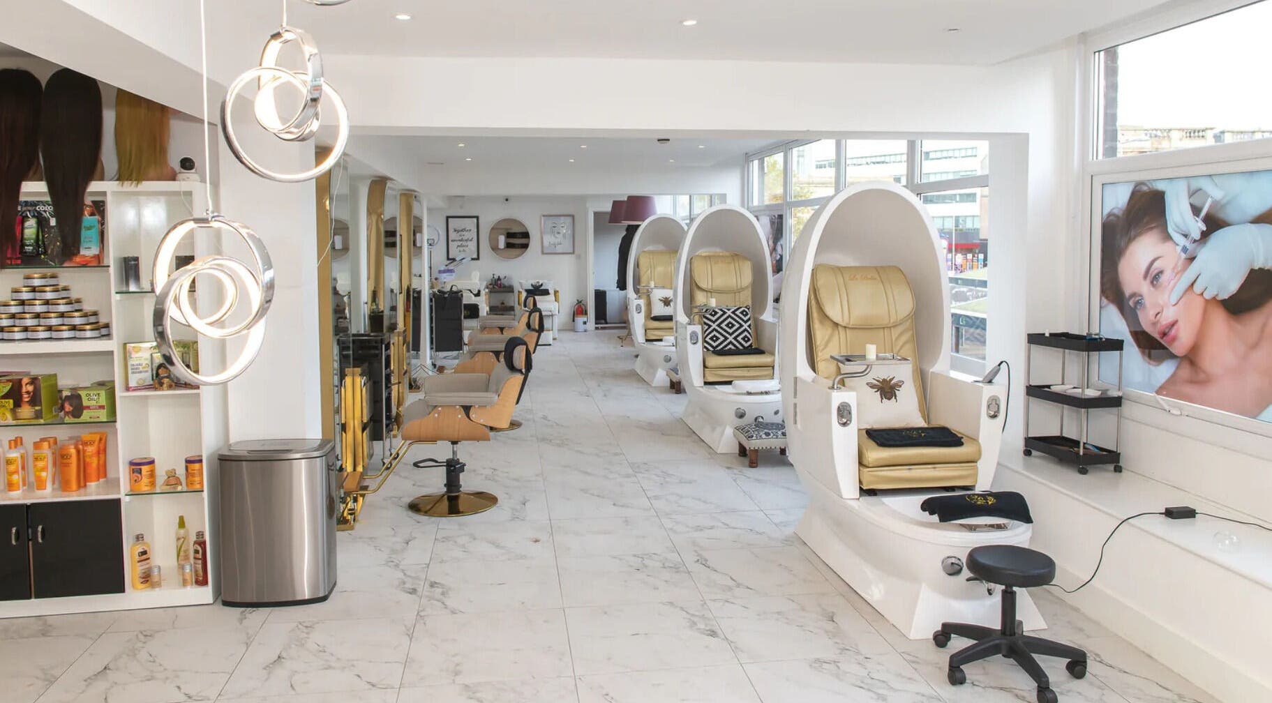 Interior view of La Bella Aesthetic Clinic, Salford, England showcasing sleek, white spa chairs and beauty product shelves.