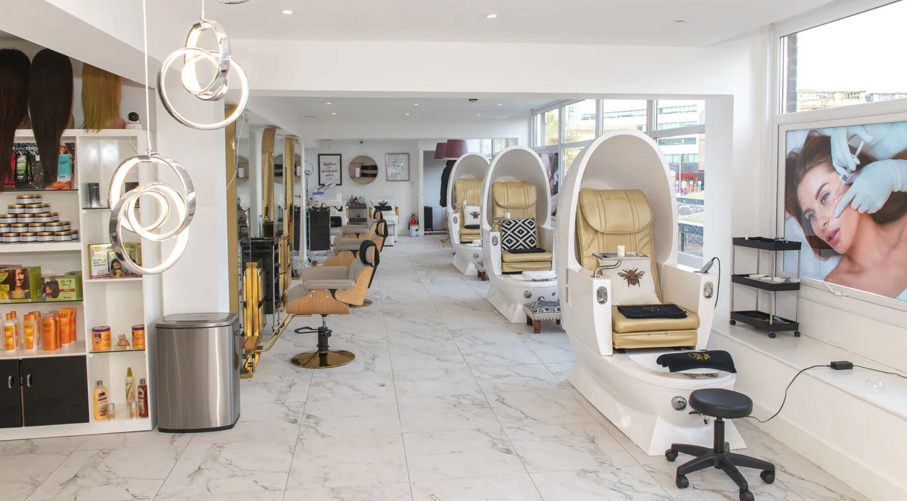 Interior view of La Bella Aesthetic Clinic, Salford, England showcasing sleek, white spa chairs and beauty product shelves.