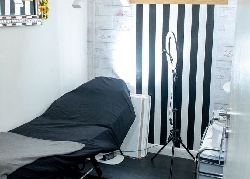 Modern treatment room at La Bella Aesthetic Clinic in Salford, England, GB featuring a striped accent wall.