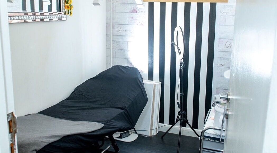 Modern treatment room at La Bella Aesthetic Clinic in Salford, England, GB featuring a striped accent wall.