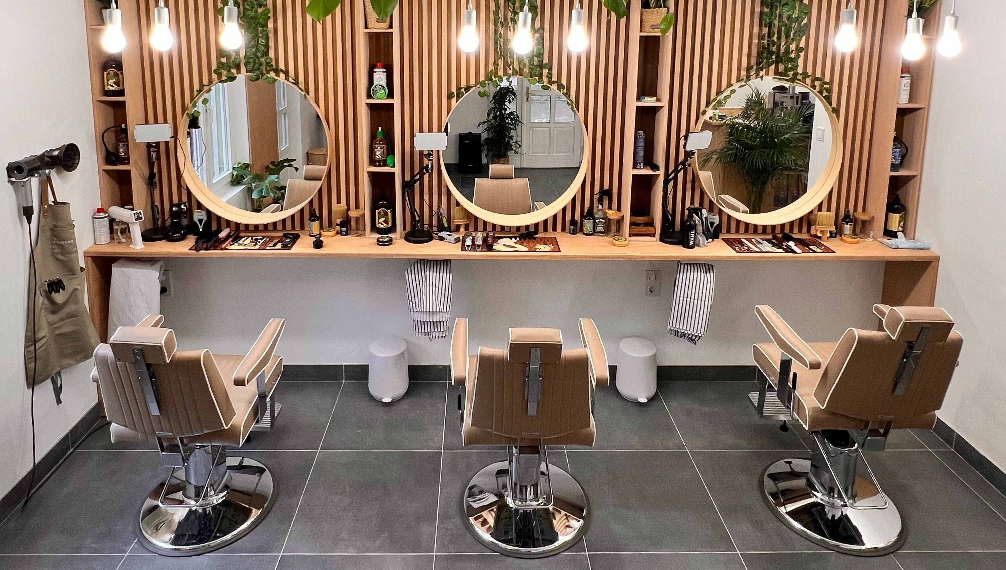 Stílusos belső tér a Fantasy Salon and Barber Budakeszi, HU helyszínen, modern székekkel és dekorációval.