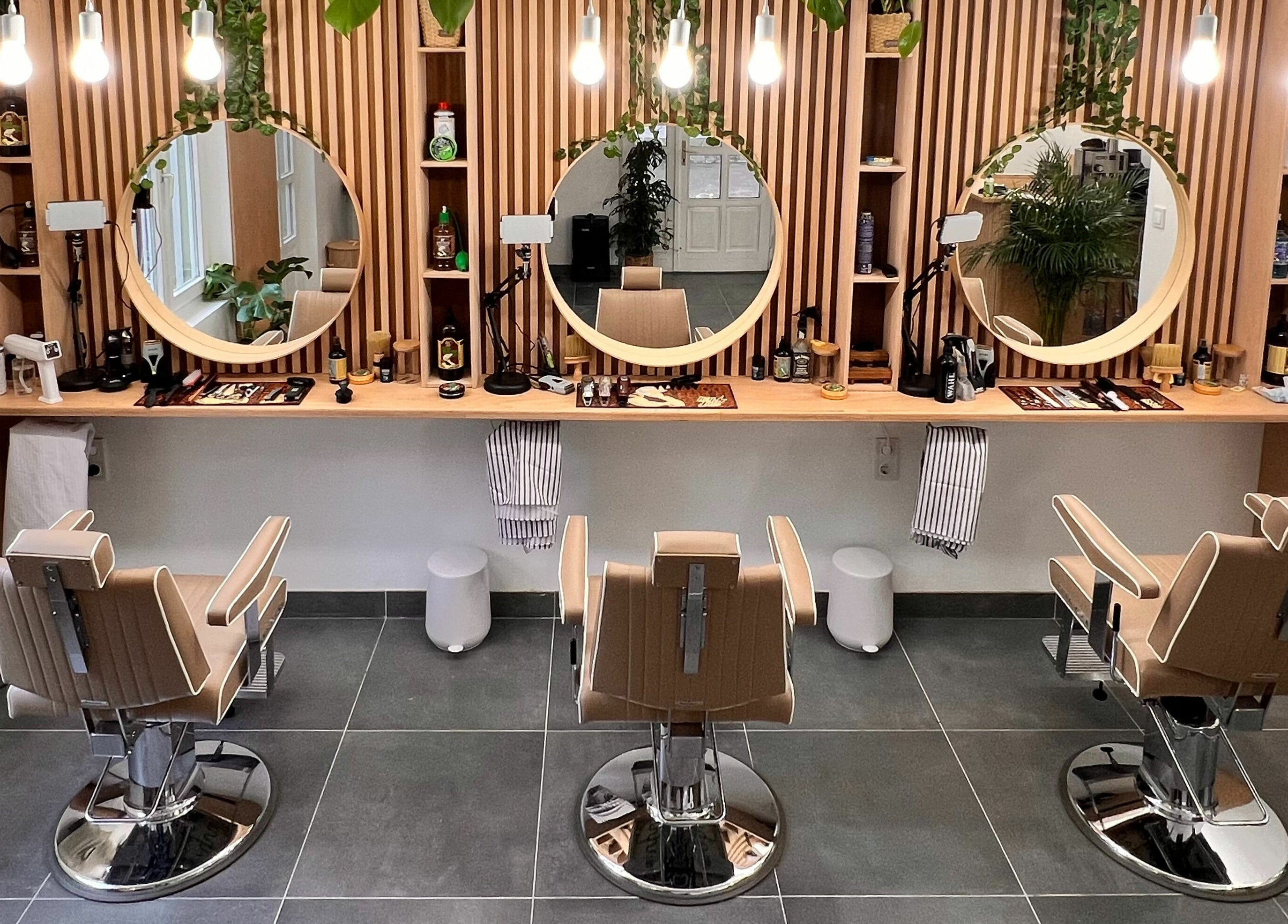 Stílusos belső tér a Fantasy Salon and Barber Budakeszi, HU helyszínen, modern székekkel és dekorációval.