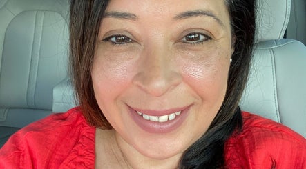 Maria Rodriguez - Aesthetician in Millsboro, Delaware, US, smiling warmly in a red top.