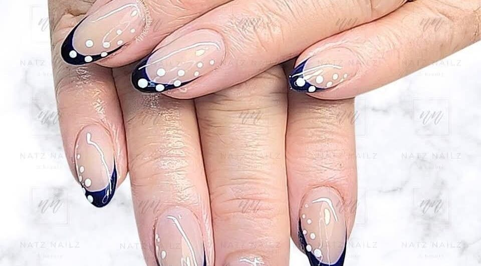 Elegant nail art with navy tips and white dots at Natz Nailz and Beauty, Parkwood, Queensland, AU.