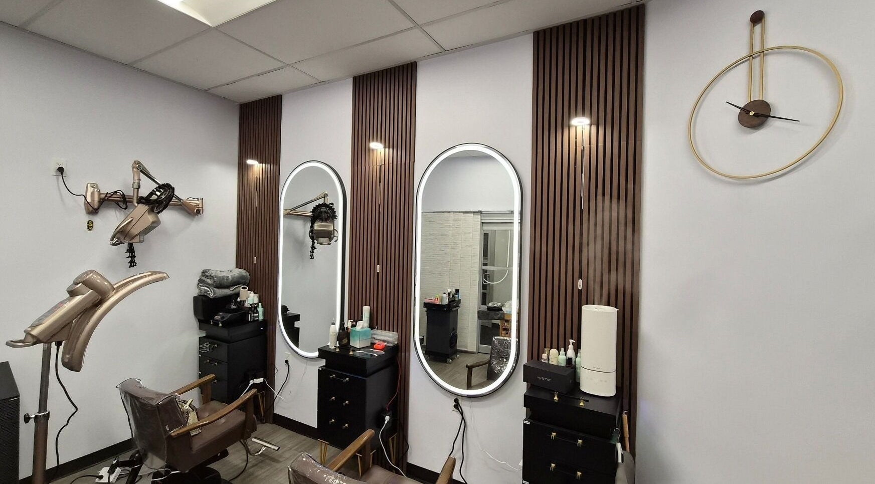 Stylish hair styling stations at One Hair in La Habra, California, US with chic modern decor and mirrors.