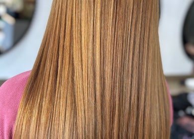 Smooth, golden brown hair at Laura Waterworth Hair in Dunmurry, Northern Ireland, GB. Salon mirror in background.