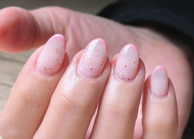 Close-up of glossy pink nails at Madame Oh La Laa, Al Khobar, SA showcasing elegant nail art.