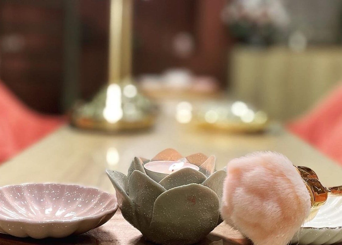 Elegant table decor at Madame Oh La Laa, Al Khobar, SA, featuring a candle and plush accessories.