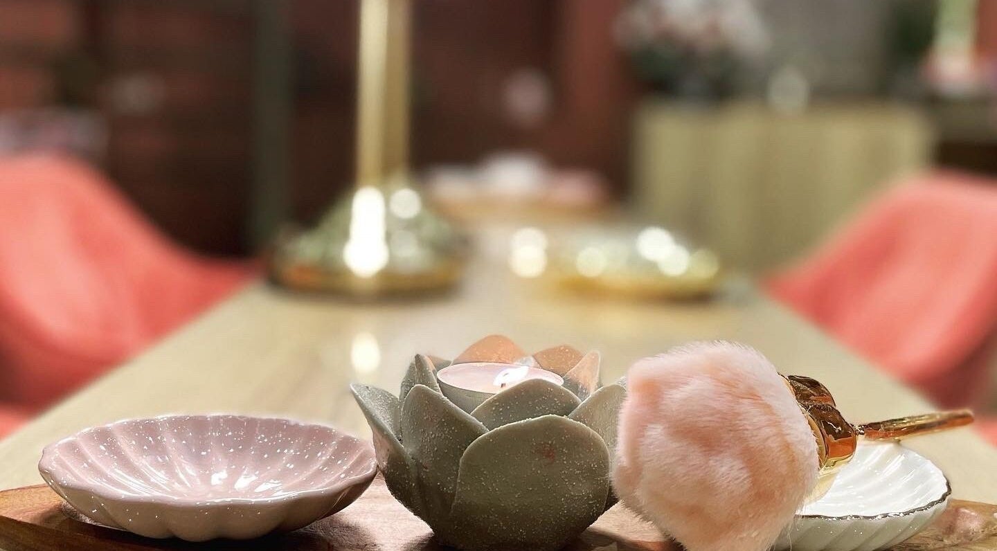 Elegant table decor at Madame Oh La Laa, Al Khobar, SA, featuring a candle and plush accessories.