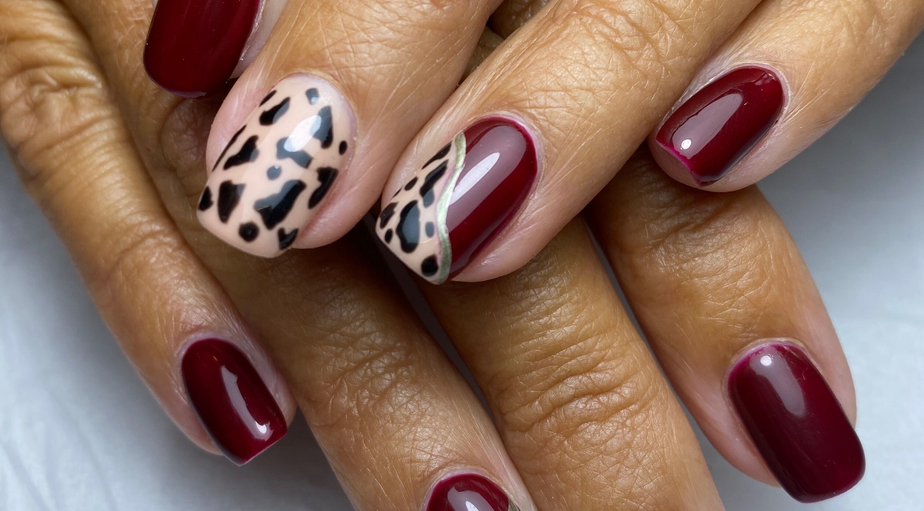Stylish nail art with burgundy and leopard design at 1913 Beauty, Huddersfield, England, GB.