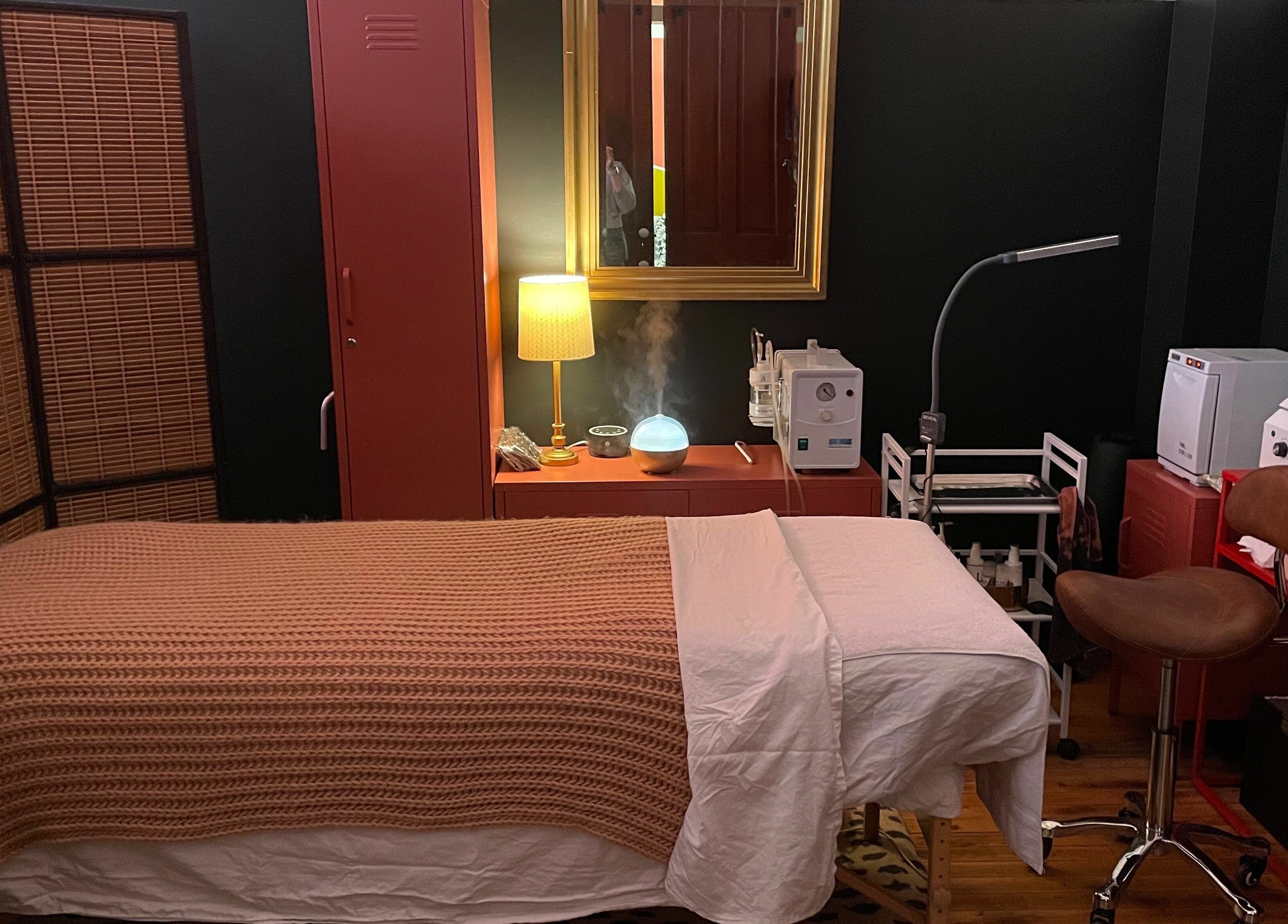 Tranquil treatment room at Pretty Things Salon in Cleveland, Ohio, US, featuring cozy bed and ambient lighting.