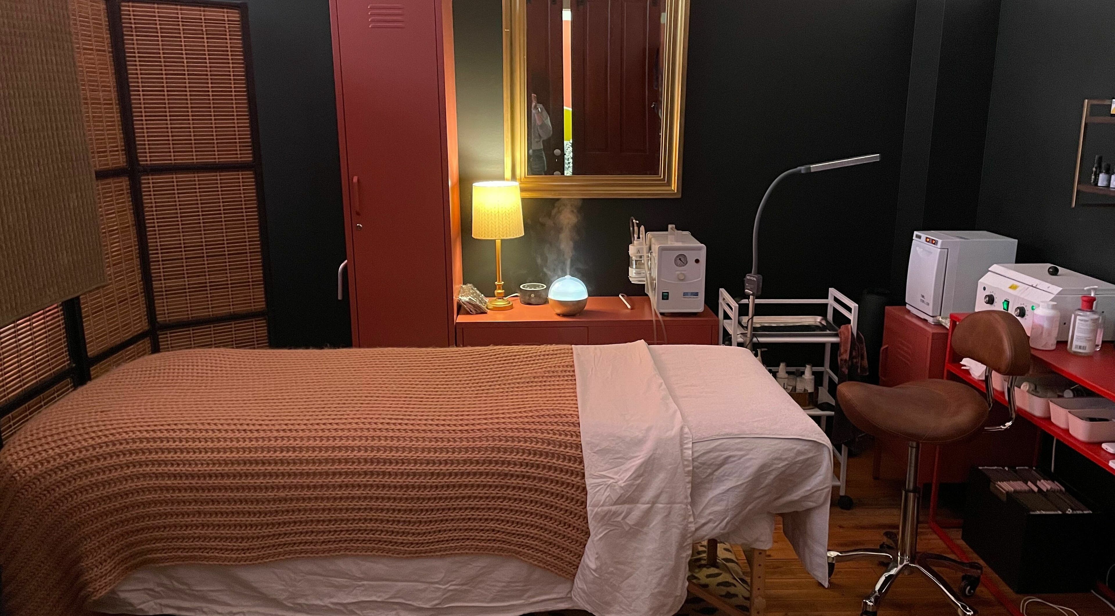Tranquil treatment room at Pretty Things Salon in Cleveland, Ohio, US, featuring cozy bed and ambient lighting.