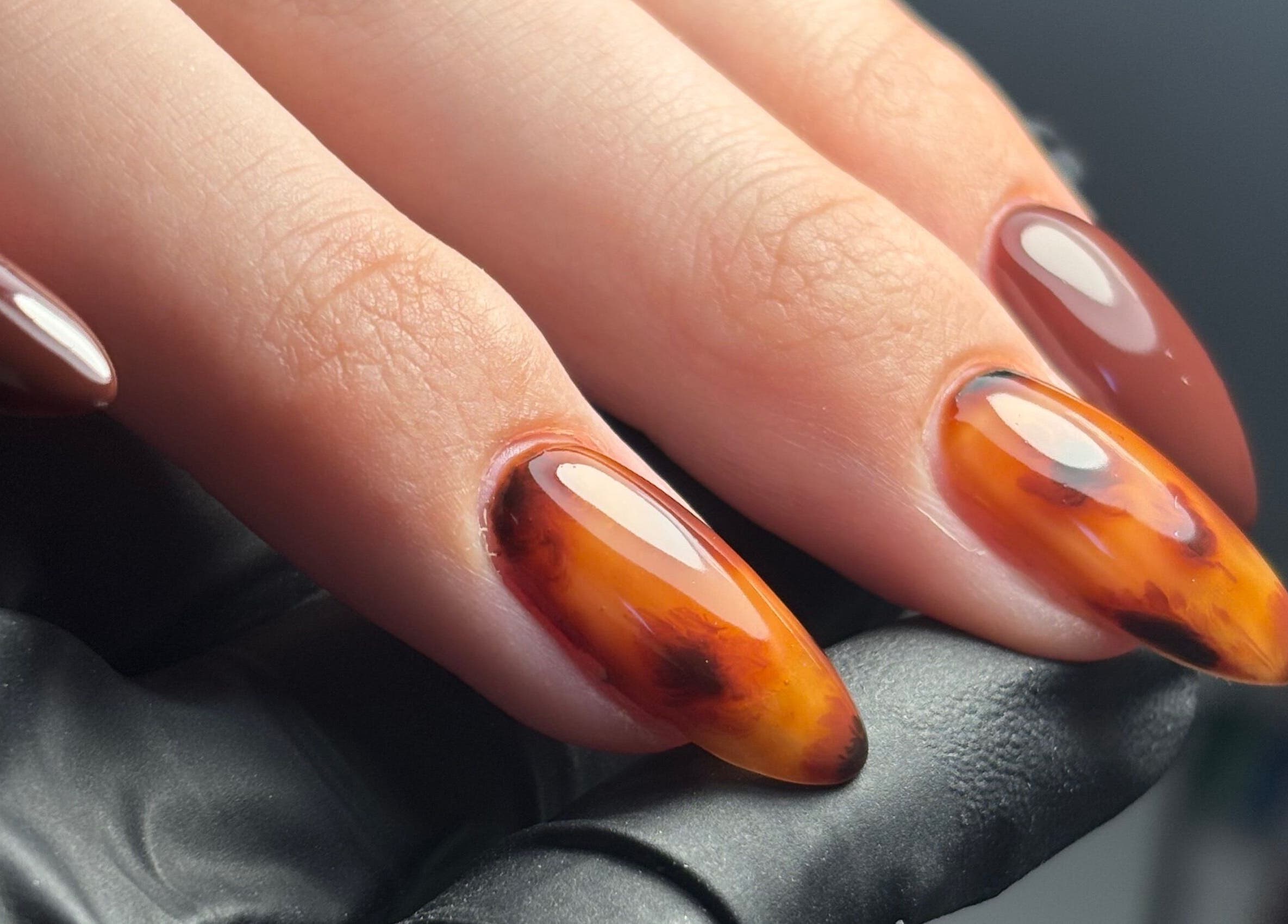 Close-up of glossy amber manicure at Sterling Co., New Plymouth, Taranaki, NZ.