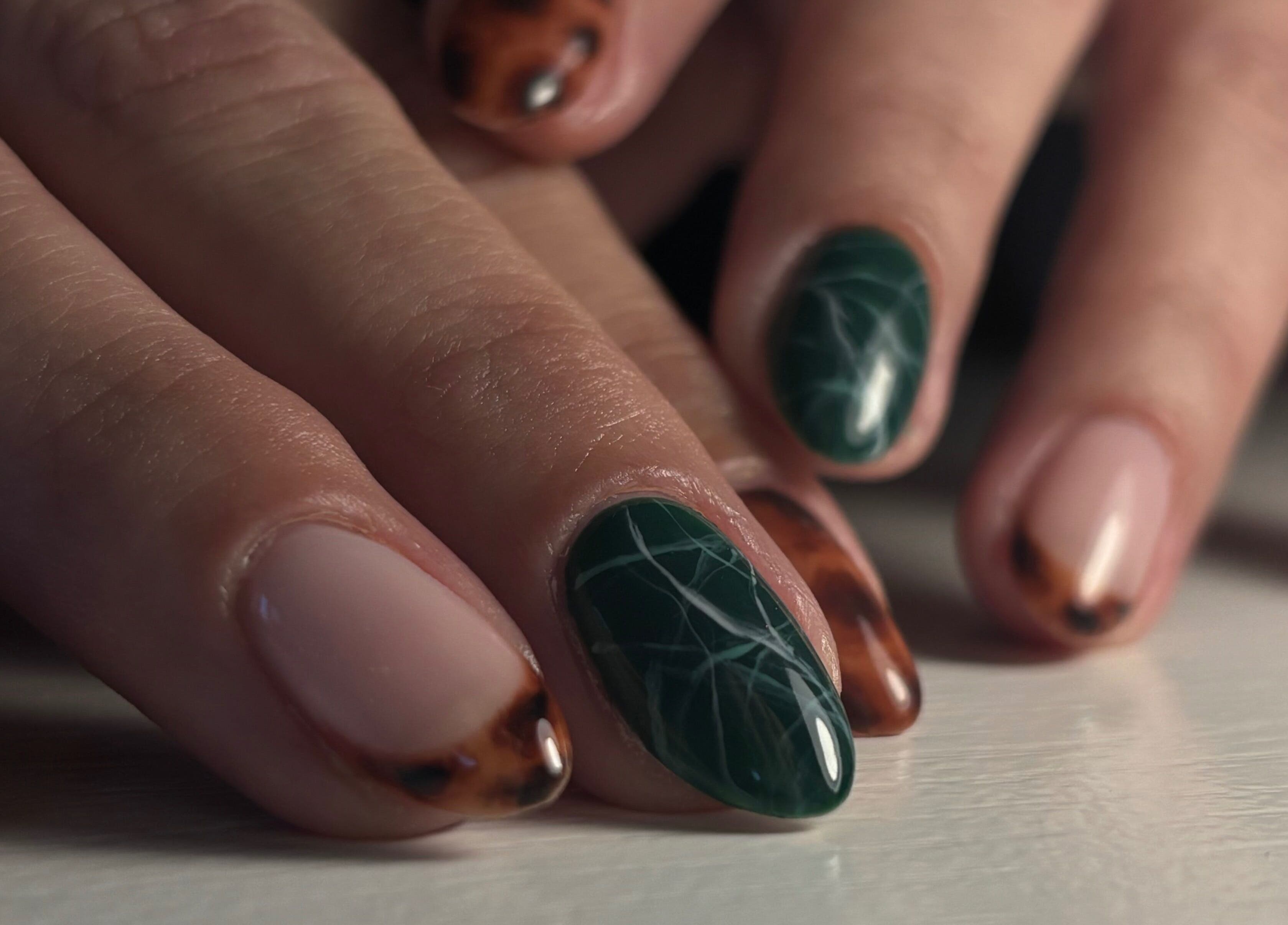 Stylish nail art at Sterling Co., New Plymouth, Taranaki, NZ, featuring dark green and tortoiseshell designs.