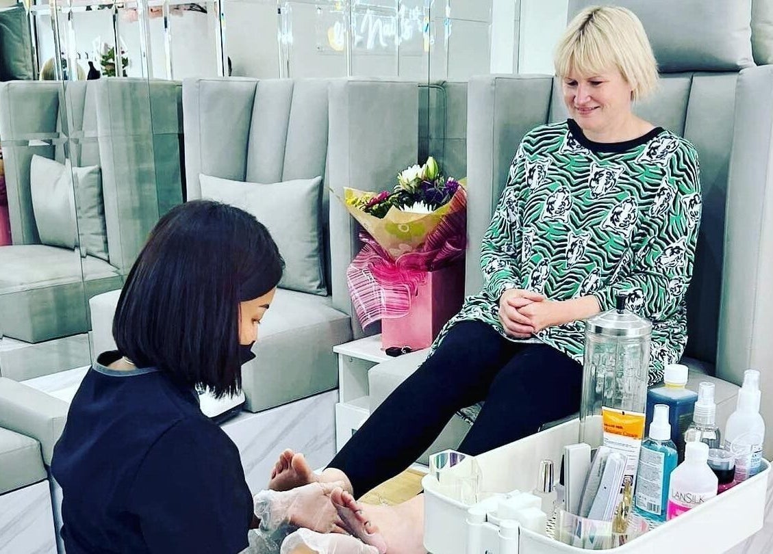 Pedicure service at Nail Spa in Penarth, Wales, GB. Woman enjoys soothing treatment with floral decor.
