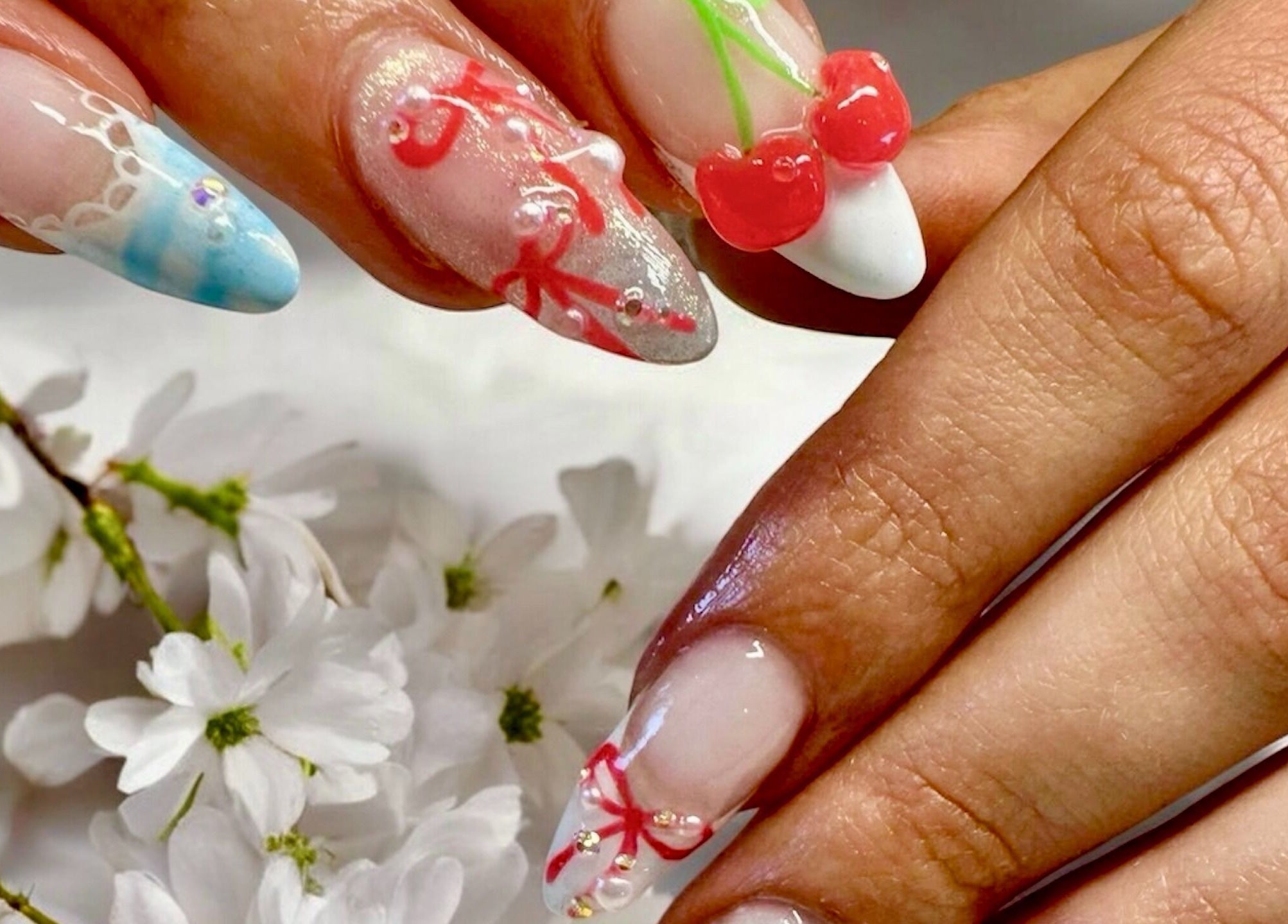 Elegant nail art with cherry design at Nail Spa, Penarth, Wales, GB, showcasing creativity and style.