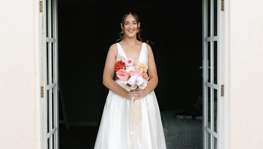 Bride holding bouquet at Tash's Tanning, Beldon, Western Australia, AU, exuding elegance at the venue entrance.