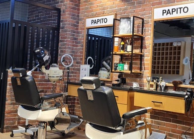 Stylish interior of Papito Barbershop in Dubai, showcasing vintage barbershop chairs and mirrors.