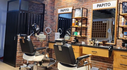 Stylish interior of Papito Barbershop in Dubai, showcasing vintage barbershop chairs and mirrors.